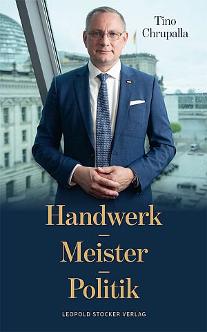Book cover for Handwerk Meister Politik by Tino Chrupalla, featuring a man in a blue suit standing by a window with a cityscape in the background.
