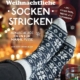 Book cover for a German knitting guide: 'Weihnachtliche Socken-Stricken' showing Nordic-pattern socks resting on feet by a lit fireplace; subtitle '24 kuschelige Ideen für warme Füße' with a tips bubble and STV logo.