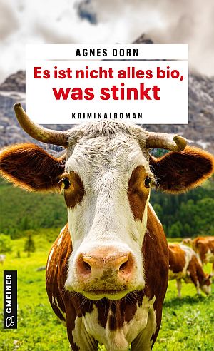 Book cover for a crime novel by Agnes Dorn, featuring a close-up cow in a meadow; title reads 'Es ist nicht alles bio, was stinkt'
